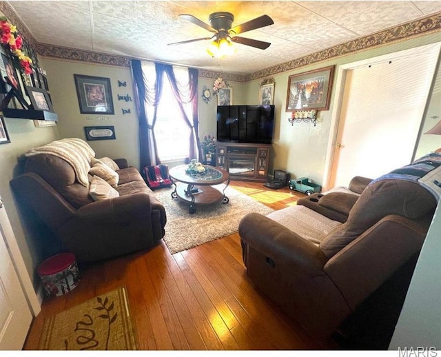 606 Olive St, Hannibal, MO 63401 - living area featuring hardwood / wood-style flooring, a ceiling fan, and an ornate ceiling