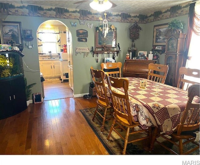 606 Olive St, Hannibal, MO 63401 - dining space with hardwood / wood-style floors, arched walkways, and a ceiling fan