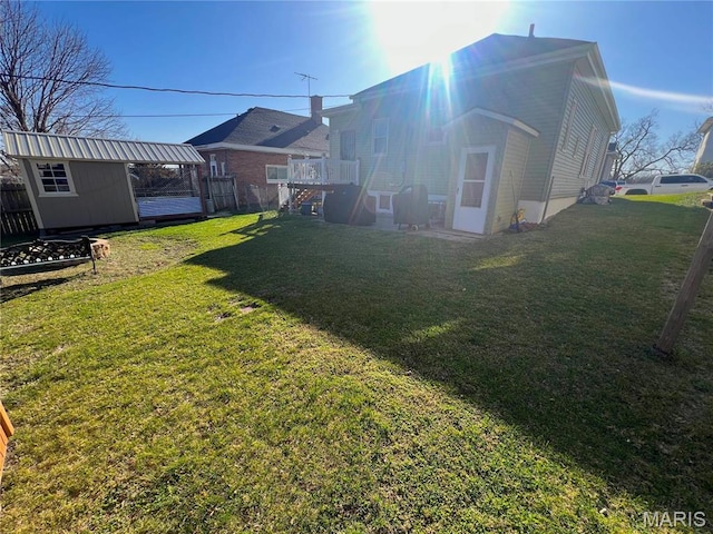 606 Olive St, Hannibal, MO 63401 - view of grassy yard with an outdoor structure, a wooden deck, and stairs