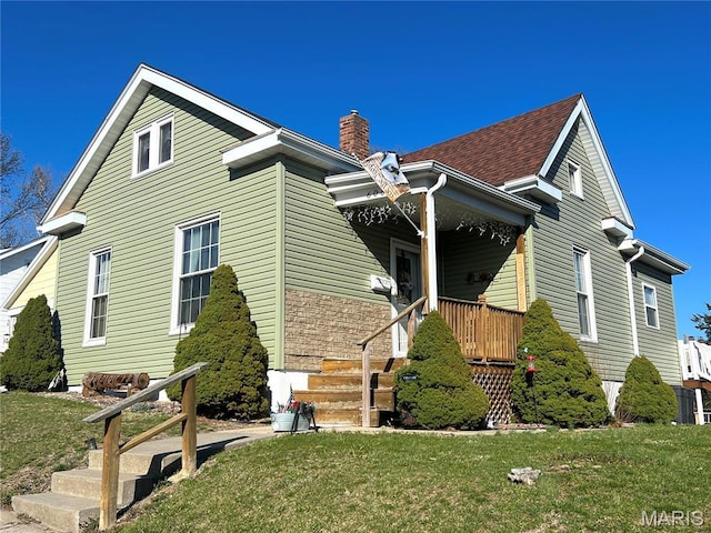 606 Olive St, Hannibal, MO 63401 - view of side of home featuring a chimney, a yard, and a porch