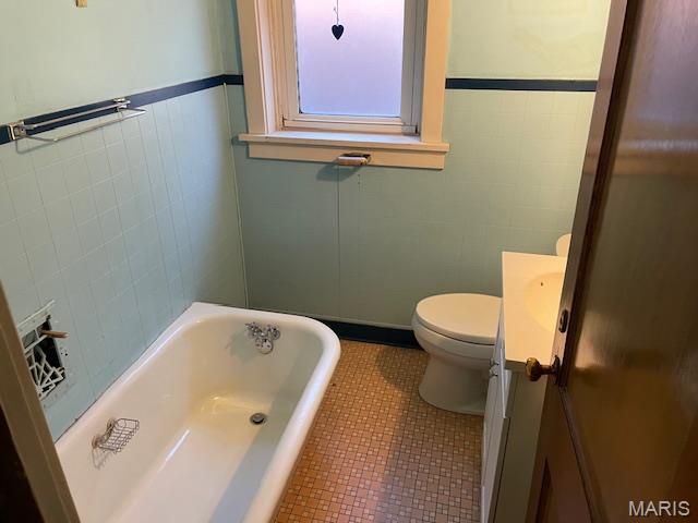 5461 Eichelberger St, Saint Louis, MO 63109 - bathroom with a bath, vanity, tile patterned floors, and a wainscoted wall