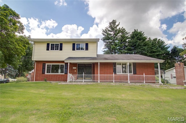1513 Colonial Dr, Godfrey, IL 62035 - view of front of house featuring brick siding, a front yard, and covered porch