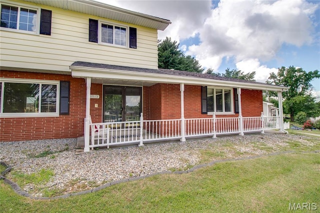 1513 Colonial Dr, Godfrey, IL 62035 - view of front of house featuring brick siding, covered porch, and a front yard