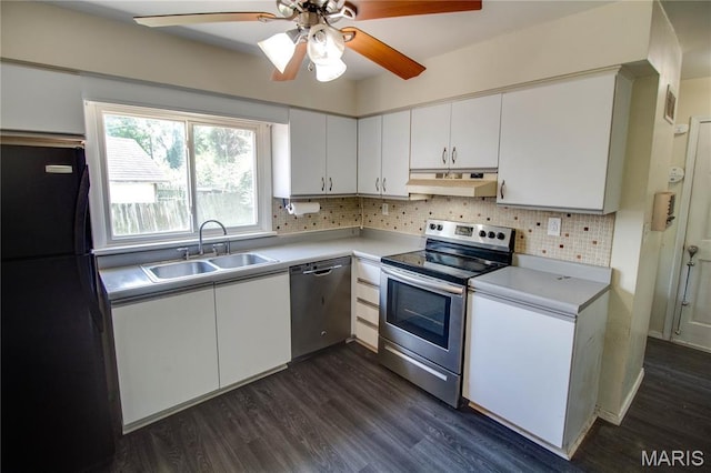 1513 Colonial Dr, Godfrey, IL 62035 - kitchen featuring stainless steel appliances, under cabinet range hood, light countertops, dark wood-style flooring, and white cabinetry