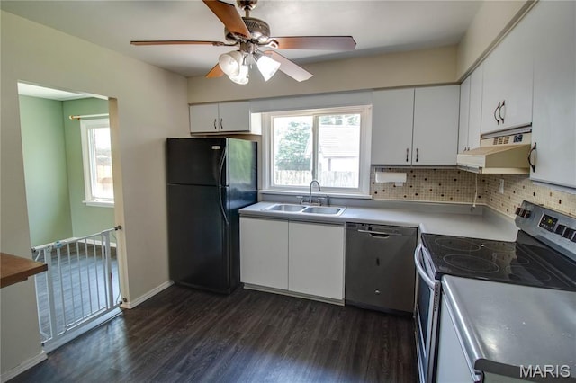 1513 Colonial Dr, Godfrey, IL 62035 - kitchen featuring appliances with stainless steel finishes, under cabinet range hood, dark wood finished floors, white cabinets, and decorative backsplash