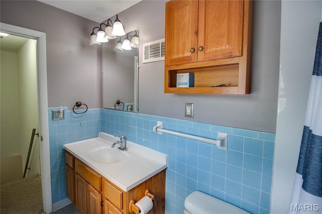 1513 Colonial Dr, Godfrey, IL 62035 - bathroom featuring tile walls, vanity, and a wainscoted wall