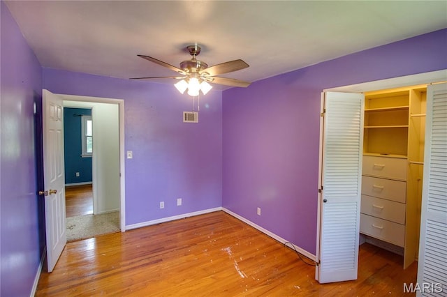 1513 Colonial Dr, Godfrey, IL 62035 - unfurnished bedroom featuring wood finished floors, a closet, and ceiling fan