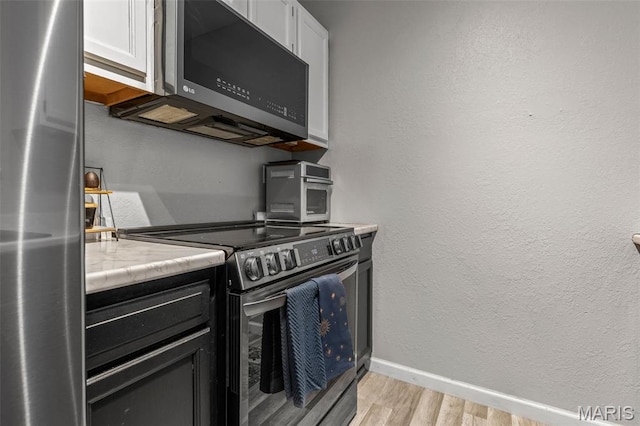 112 Dale Dr, Hillsboro, MO 63050 - kitchen featuring appliances with stainless steel finishes, light wood-style flooring, light countertops, and white cabinets