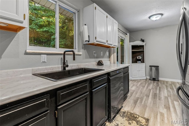 112 Dale Dr, Hillsboro, MO 63050 - kitchen featuring dishwasher, light countertops, light wood-style floors, freestanding refrigerator, and white cabinetry