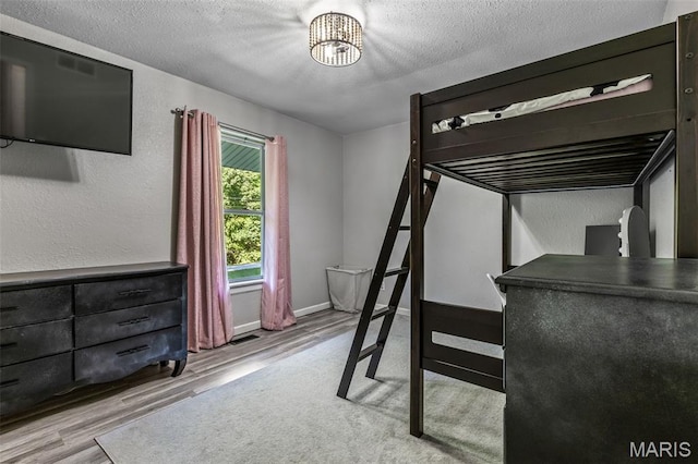 112 Dale Dr, Hillsboro, MO 63050 - unfurnished bedroom with wood finished floors, a textured ceiling, and a chandelier