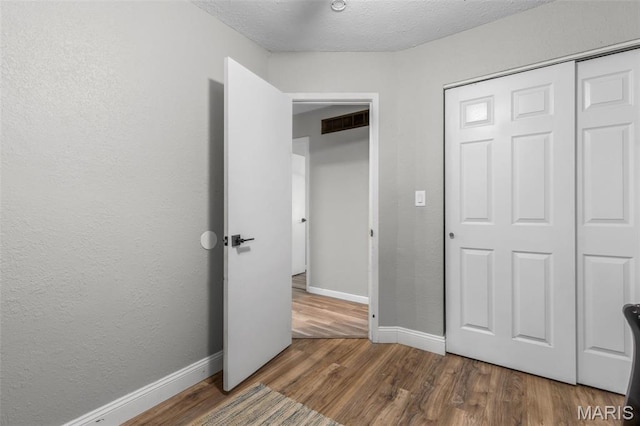 112 Dale Dr, Hillsboro, MO 63050 - unfurnished bedroom featuring wood finished floors, a textured wall, a closet, and a textured ceiling