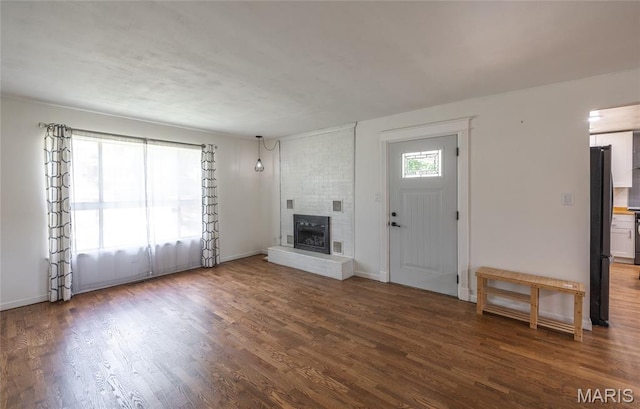 920 E 7th St, Rolla, MO 65401 - unfurnished living room with wood finished floors and a brick fireplace