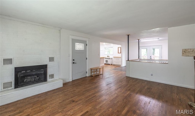 920 E 7th St, Rolla, MO 65401 - unfurnished living room with wood finished floors and a brick fireplace