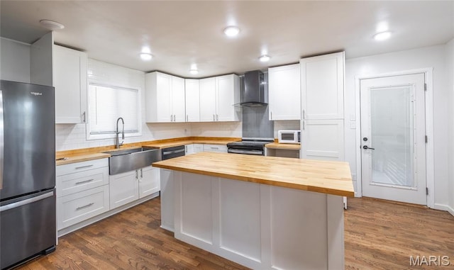 920 E 7th St, Rolla, MO 65401 - kitchen featuring butcher block countertops, freestanding refrigerator, wall chimney exhaust hood, white microwave, and range with electric cooktop