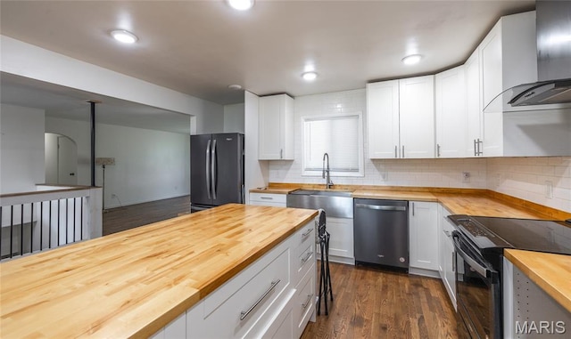 920 E 7th St, Rolla, MO 65401 - kitchen with butcher block counters, freestanding refrigerator, stainless steel dishwasher, range hood, and black electric range oven