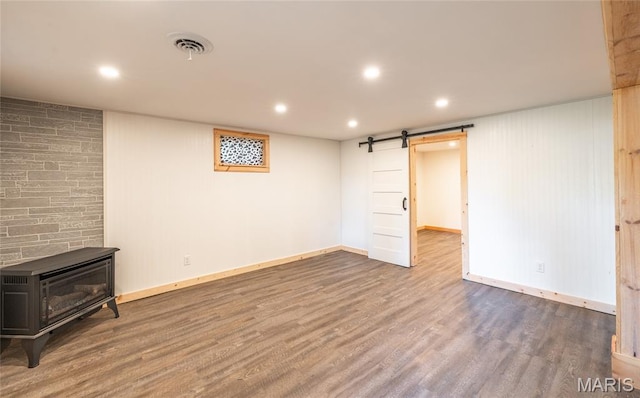 920 E 7th St, Rolla, MO 65401 - finished basement with a barn door, a wood stove, wood finished floors, and recessed lighting