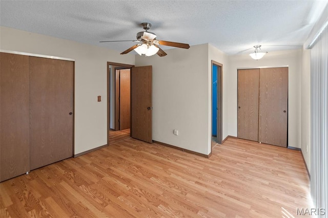 607 Sparrow Ct, Troy, IL 62294 - unfurnished bedroom featuring light wood finished floors, multiple closets, a textured ceiling, and ceiling fan