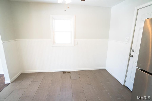 11005 Florence Ave, Saint Ann, MO 63074 - unfurnished room with a wainscoted wall, a ceiling fan, and wood finished floors