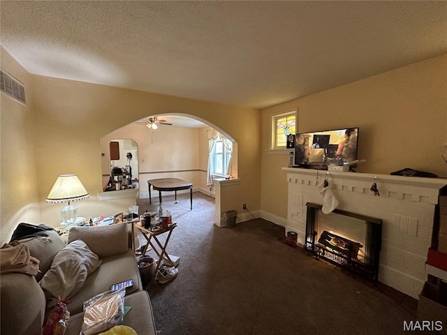 720 Tiffin Ave, Ferguson, MO 63135 - living room featuring arched walkways, carpet floors, a brick fireplace, and ceiling fan