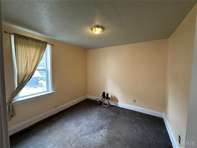 720 Tiffin Ave, Ferguson, MO 63135 - empty room featuring dark carpet and a textured ceiling