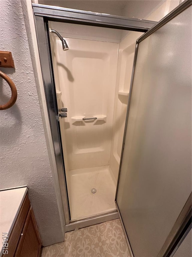 720 Tiffin Ave, Ferguson, MO 63135 - bathroom with a shower stall, a textured wall, and tile patterned flooring