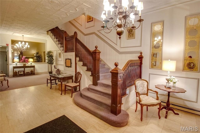 417 Prospect St Unit A, Alton, IL 62002 - staircase featuring a chandelier, a baseboard heating unit, a wainscoted wall, and a decorative wall