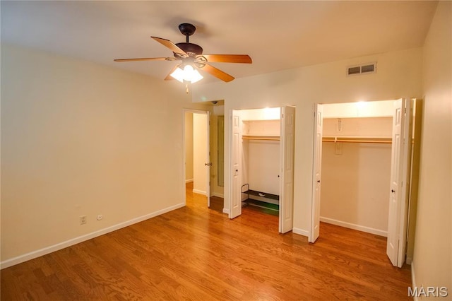 417 Prospect St Unit A, Alton, IL 62002 - unfurnished bedroom with multiple closets, light wood-type flooring, and ceiling fan