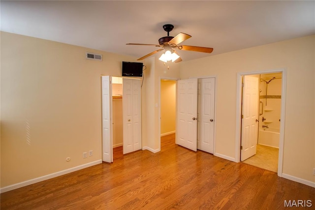 417 Prospect St Unit A, Alton, IL 62002 - unfurnished bedroom with wood finished floors, connected bathroom, multiple closets, and ceiling fan