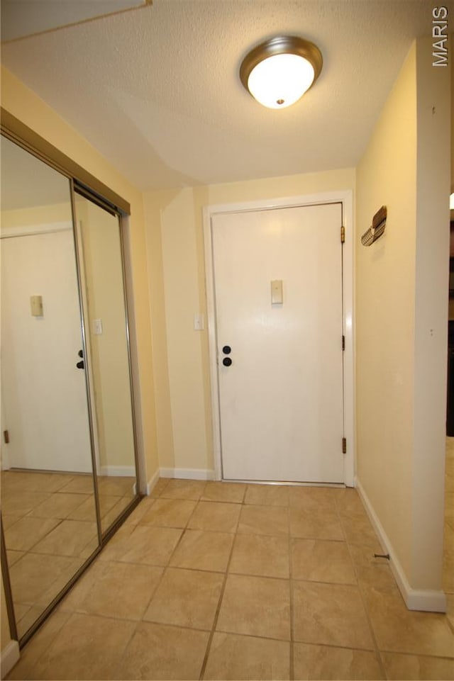 1400 Heritage Lndg Unit 106, Saint Charles, MO 63303 - doorway with a textured ceiling and light tile patterned floors