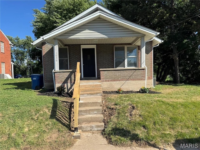 1036 Olive St, Saint Charles, MO 63301 - bungalow with brick siding, a front lawn, and a porch