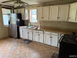 570 Washington Pl E, St Louis, IL 62205 - kitchen featuring black range oven, stainless steel refrigerator with ice dispenser, ceiling fan, and white cabinets