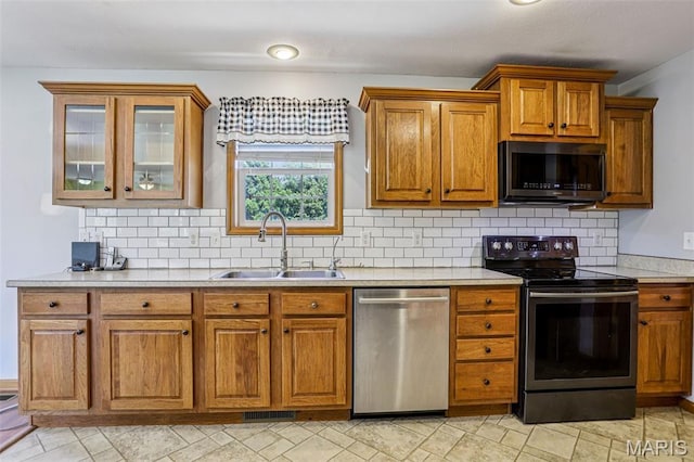 1518 Old Ripley Rd, Sorento, IL 62086 - kitchen with appliances with stainless steel finishes, brown cabinets, light countertops, backsplash, and glass insert cabinets