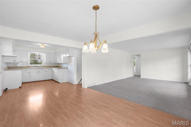 114 Macarthur St, New Haven, MO 63068 - kitchen with a chandelier, white cabinets, open floor plan, light countertops, and pendant lighting