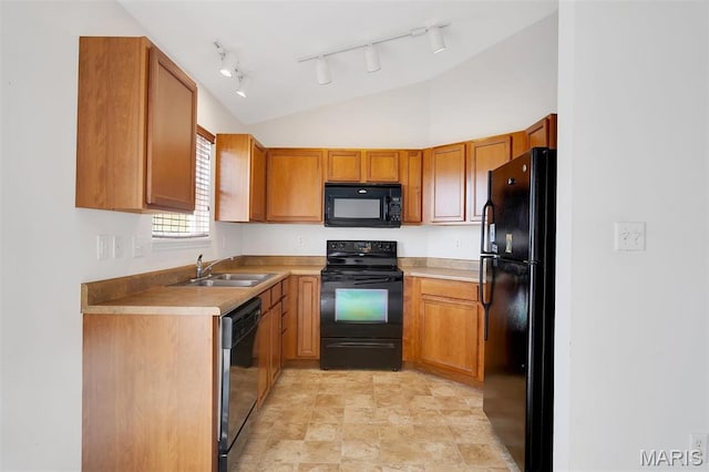 32 Brushy Brook Ct, Ofallon, MO 63366 - kitchen featuring black appliances, rail lighting, brown cabinets, vaulted ceiling, and light countertops