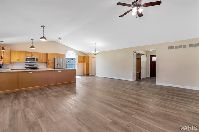 2601 Brookfield Ct, Columbia, IL 62236 - unfurnished living room featuring a barn door, vaulted ceiling, ceiling fan, a chandelier, and wood finished floors