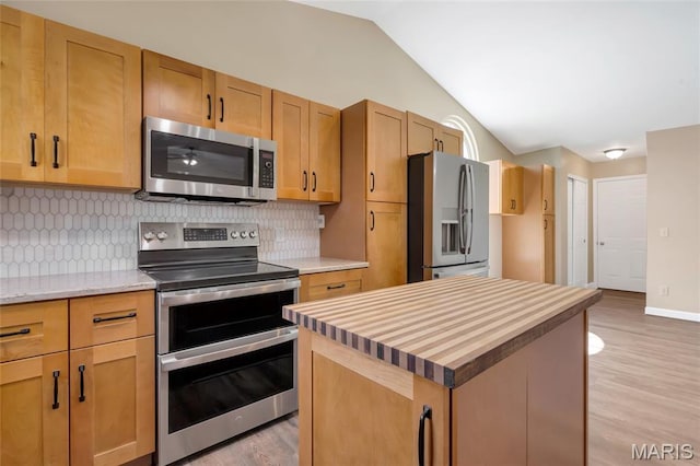 2601 Brookfield Ct, Columbia, IL 62236 - kitchen featuring stainless steel appliances, light wood-type flooring, decorative backsplash, vaulted ceiling, and a kitchen island