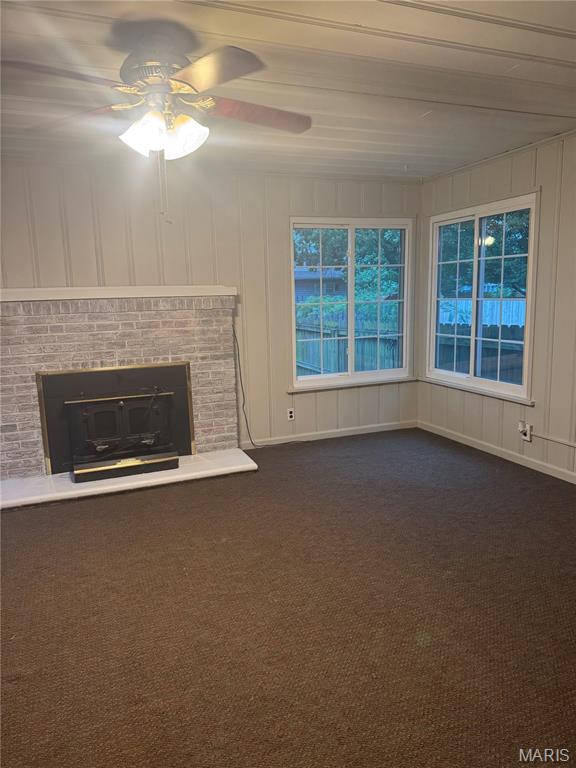 2544 State St, Granite City, IL 62040 - unfurnished living room featuring ceiling fan, dark carpet, and a brick fireplace