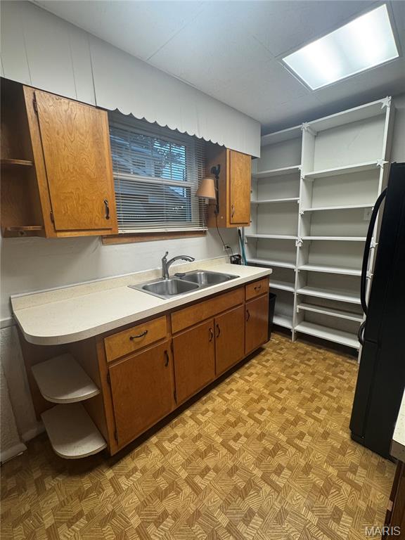 2544 State St, Granite City, IL 62040 - kitchen with open shelves, freestanding refrigerator, brown cabinetry, and light flooring