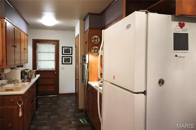337 S Elm St, Dexter, MO 63841 - kitchen with freestanding refrigerator, oven, light countertops, and brown cabinetry