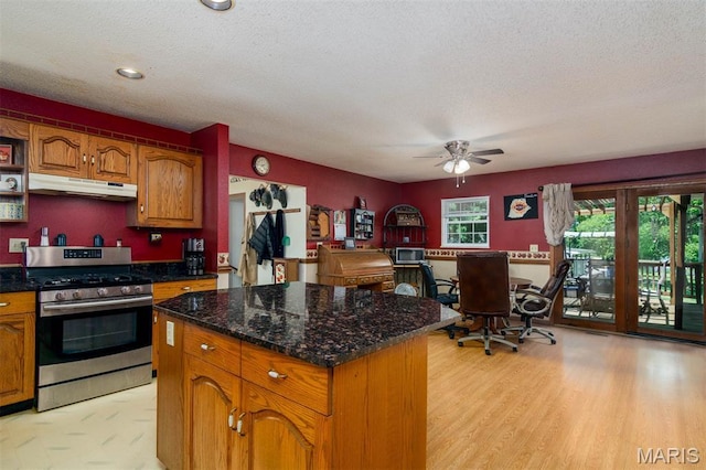 2364 Marine Rd, Highland, IL 62249 - kitchen with stainless steel gas range oven, under cabinet range hood, ceiling fan, brown cabinets, and a textured ceiling