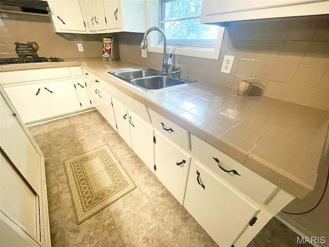 304 W Oak St, Dexter, MO 63841 - kitchen with tasteful backsplash, tile countertops, white cabinets, and gas stovetop