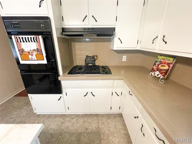 304 W Oak St, Dexter, MO 63841 - kitchen featuring under cabinet range hood, black appliances, white cabinets, and tasteful backsplash
