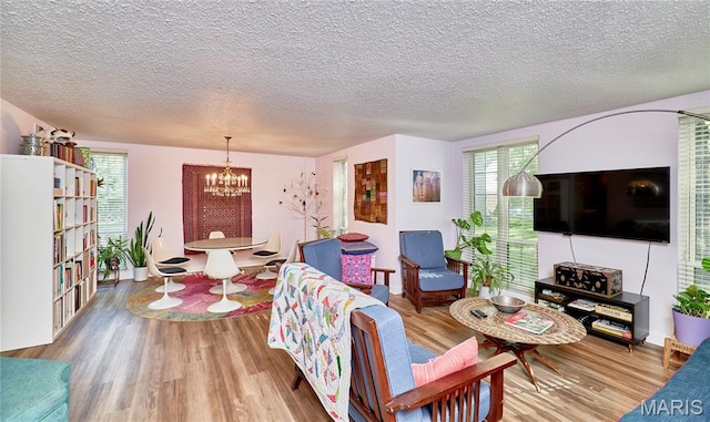 922 Claytonbrook Dr Unit 2, Ballwin, MO 63011 - living room featuring a chandelier, wood finished floors, and a textured ceiling