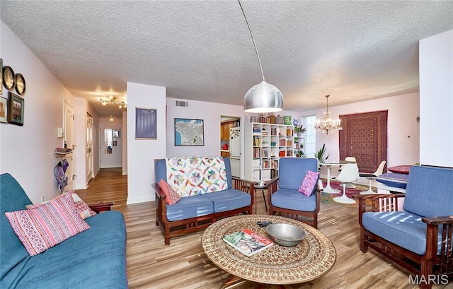 922 Claytonbrook Dr Unit 2, Ballwin, MO 63011 - living area with wood finished floors, a chandelier, and a textured ceiling