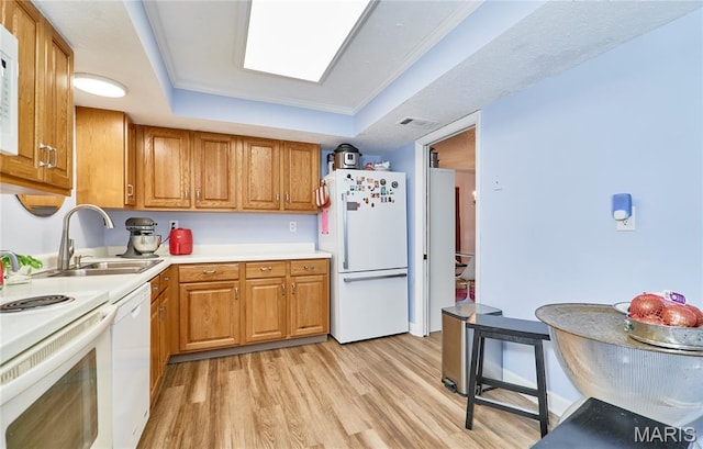 922 Claytonbrook Dr Unit 2, Ballwin, MO 63011 - kitchen featuring white appliances, a raised ceiling, light wood finished floors, brown cabinetry, and light countertops