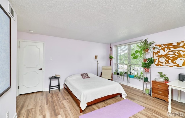 922 Claytonbrook Dr Unit 2, Ballwin, MO 63011 - bedroom featuring light wood-type flooring and a textured ceiling