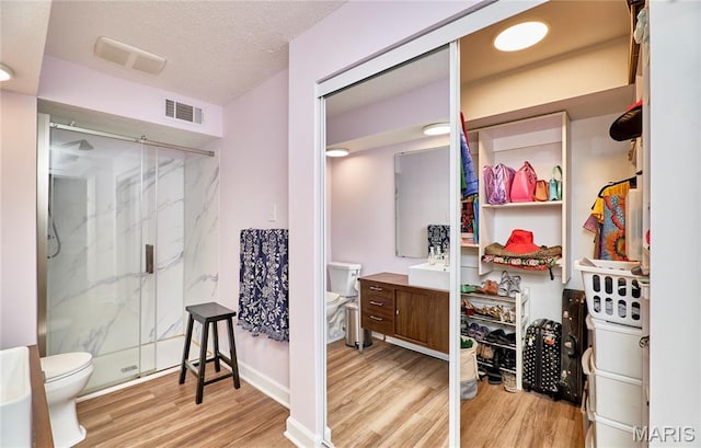 922 Claytonbrook Dr Unit 2, Ballwin, MO 63011 - full bath featuring wood finished floors, a marble finish shower, vanity, and a textured ceiling