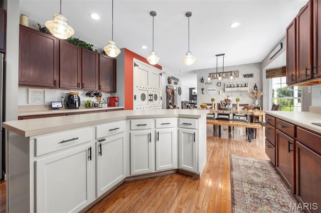 7742 Ardmore Dr, Ofallon, MO 63368 - kitchen with light countertops, light wood-type flooring, white cabinets, pendant lighting, and recessed lighting