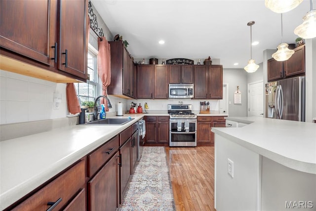 7742 Ardmore Dr, Ofallon, MO 63368 - kitchen with appliances with stainless steel finishes, light wood-type flooring, light countertops, tasteful backsplash, and recessed lighting