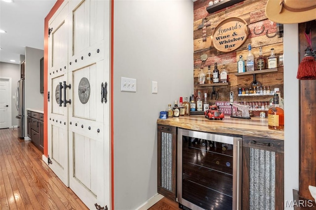 7742 Ardmore Dr, Ofallon, MO 63368 - indoor dry bar featuring wine cooler, freestanding refrigerator, recessed lighting, and light wood-style floors